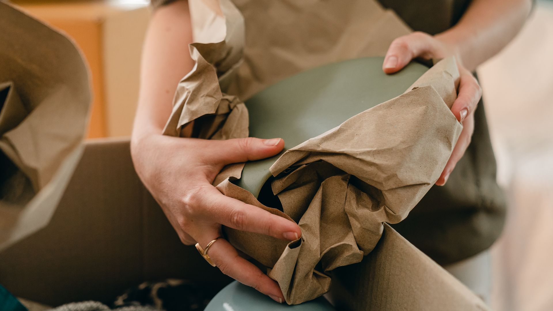 Hands packing a parcel for dispatch